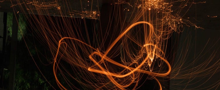 Long exposure light painting glowing orange fire trails and sparks at night delightful Impressions