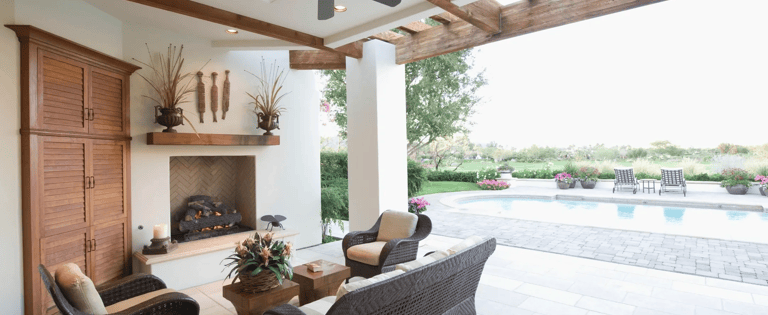 a patio with wicker furniture and a fireplace