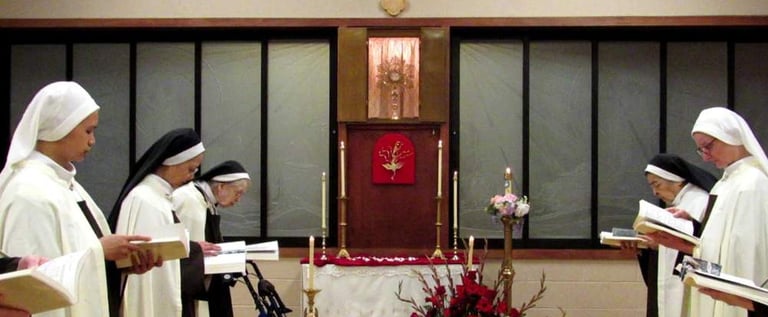 Nuns praying in the choir with the Blessed Sacrament exposed.