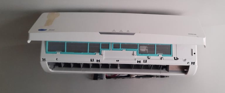 A wall-mounted split system air conditioner unit with its front cover panel open for maintenance and cleaning.