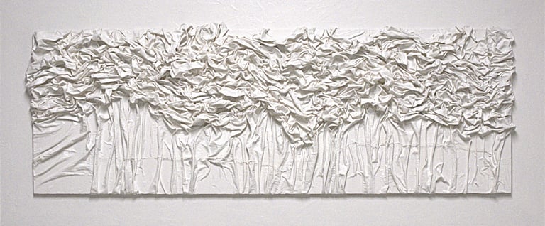 White 3D textured fabric wall art featuring vertical folds and crumpled abstract patterns.