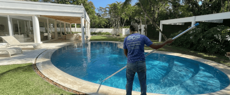 Piscineiro realizando limpeza e manutenção mensal de piscina em Jacarepaguá - S.O.S Piscinas.