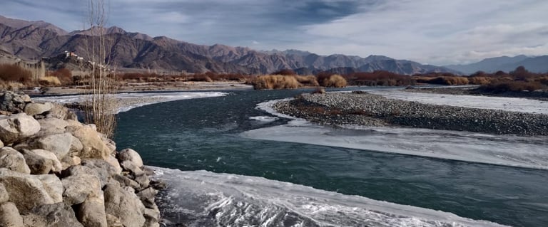 a river with ice and snow on the ground