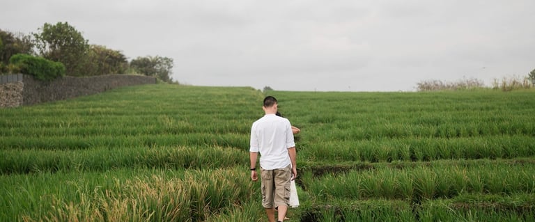 Groom walking through rice field pathway at Waka Gangga Tabanan Bali