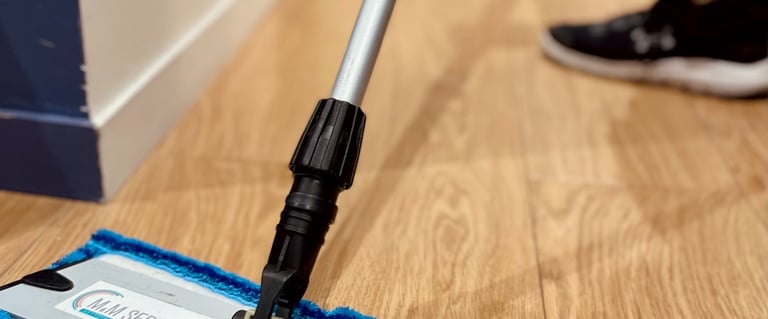 Technicien de M & M Services Pro passant la serpillière bleue dans un local professionnel à Rouen