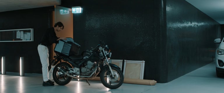 a man standing next to a motorcycle in a garage