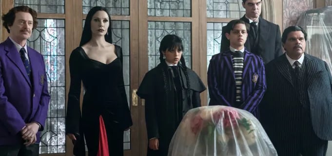 Scene from Wednesday Season 2 showing the Addams family dressed in black at a formal event or funera