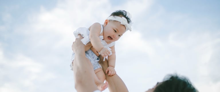 Father lifting baby into the air during family photography session at Sofitel Nusa Dua Bali