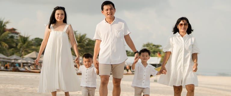 Parents walking with their children along the beach at The Apurva Kempinski Nusa Dua Bali