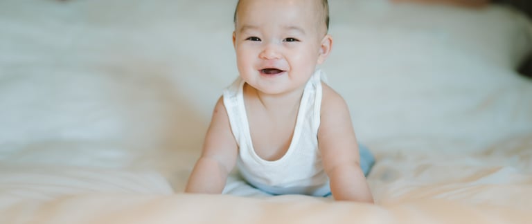 Baby portrait on bed at Intercontinental Jimbaran captured in soft natural light during a family photography session