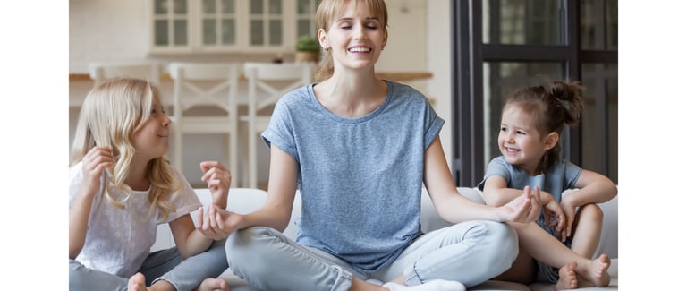 A mother practicing mindfulness with her children to promote relaxation and stress management