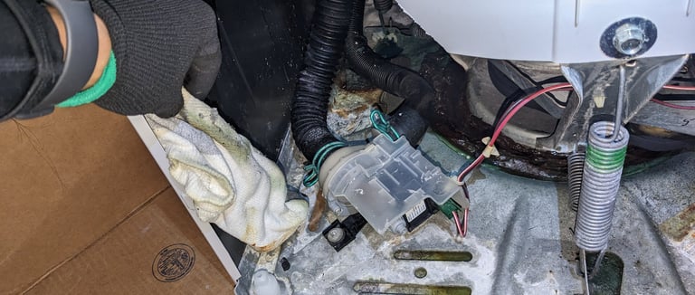front panel off washing machine. A technician holding a sock
