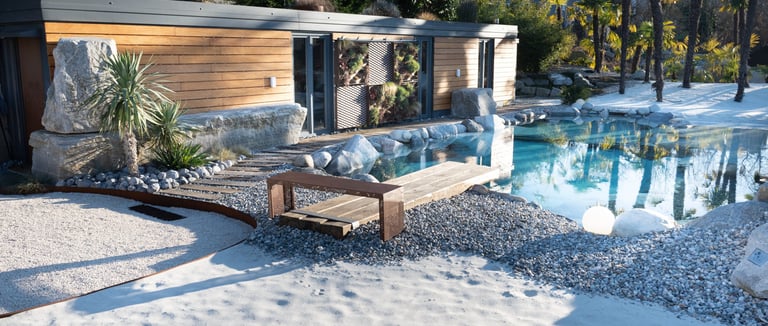 modulo prefabbricato a bordo piscina naturale con rocce e spiaggia bianca
