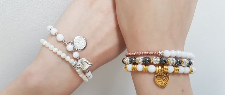 a woman's hands wearing white bead bracelets