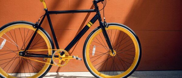 a black bicycle with a yellow rim 