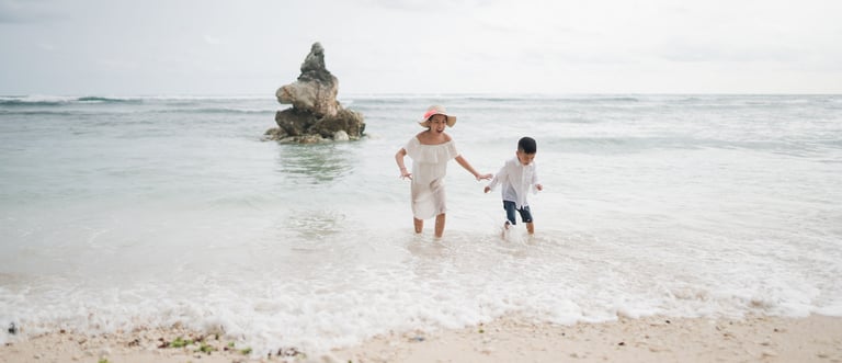Family walking along the open shoreline of Melasti Beach Bali during a peaceful family photography session