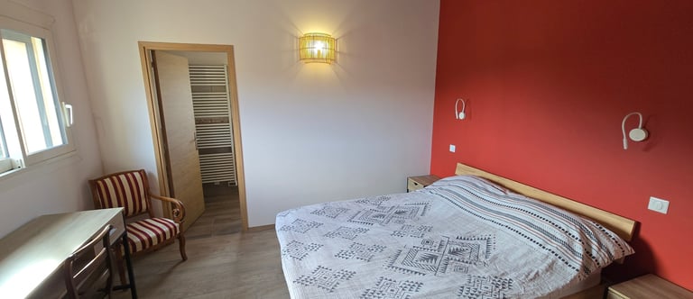 Chambre d'hôtes refaite à neuf avec lit double, chaise et bureau.