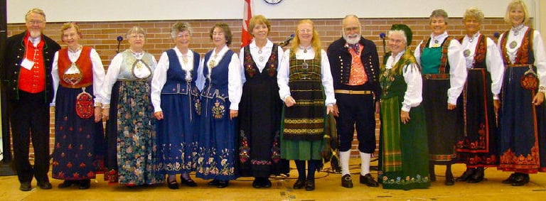 2 men and 10 women wearing bunad at a stevne
