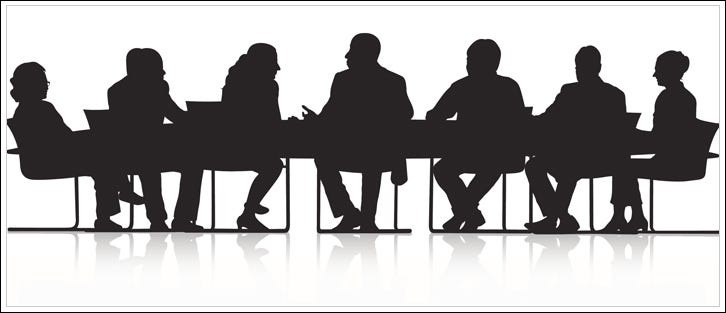 Silouhettes of people sitting at a conference table