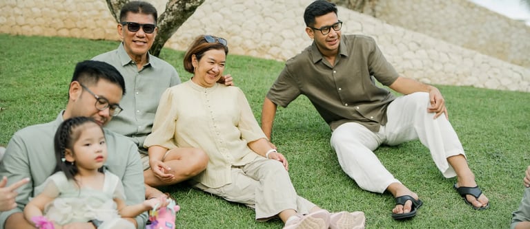 Three generation family relaxing together on a tropical garden lawn during a family photography session in Bali.