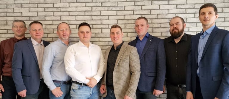 a group of men standing in front of a brick wall