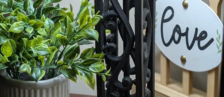 a stand in my home with plant, soft lamp light, & love decor