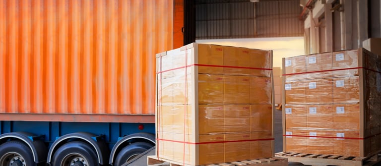 Cargo pallets on warehouse dock, semi truck with shipping container, Specialty Logistics, Louisville