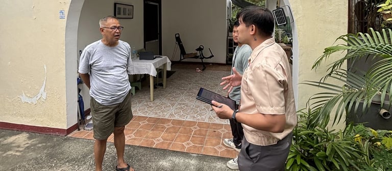 A real estate agent discusses a property with a client outside an arched house entrance.