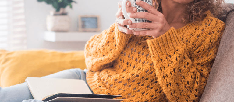 a woman sitting on a couch holding a coffee cup