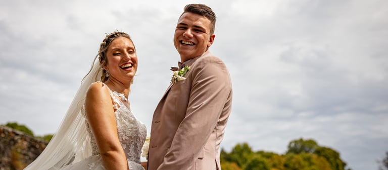 a bride and groom standing in front of a tree