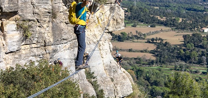 persona cruzando un puente colgante