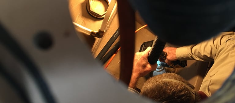 man working in compartment of boat