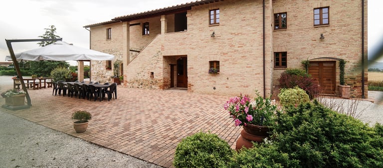 Veduta esterna del casale e giardino in una giornata nuvolosa