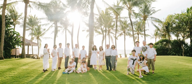 Extended family group session on the lawn at The Legian Seminyak Bali during golden hour.