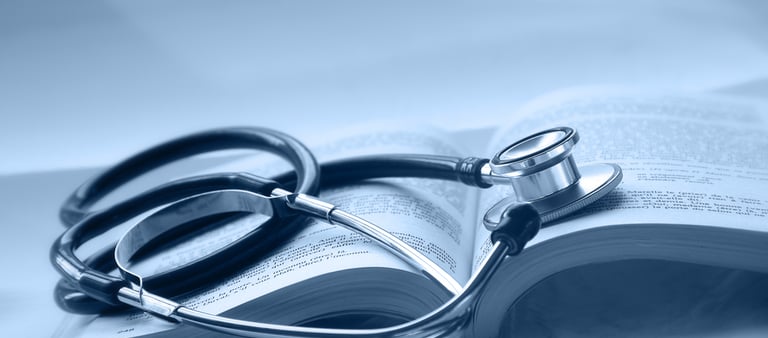 An open medical book with a stethoscope on top of it