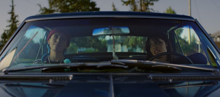 a man and woman in a car driving down a road