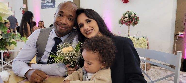Imagem onde estou com minha família, filho, esposa, em uma festa de casamentos, sentados a mesa.