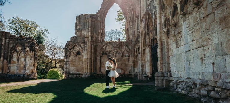 Bride standing near historic stone ruins in York, photographed by Fred Art Studio.