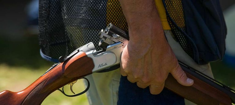 man holding an over under shotgun