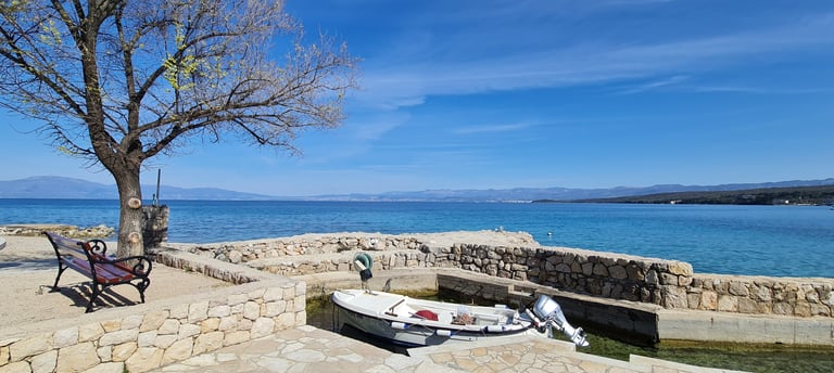 Kleiner Anlegeplatz mit Boot an der Küste von Malinska