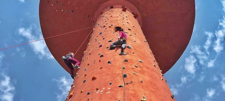 a person climbing on a climbing tower