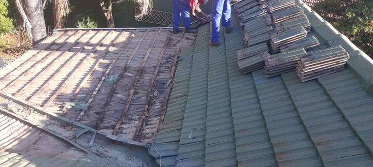 Roof tiles removed to expose damaged battens and waterlogged timber
