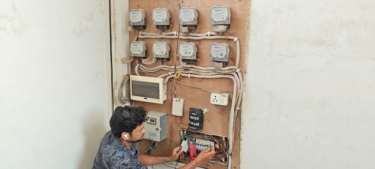 a man in a blue shirt is working on a electrical panel
