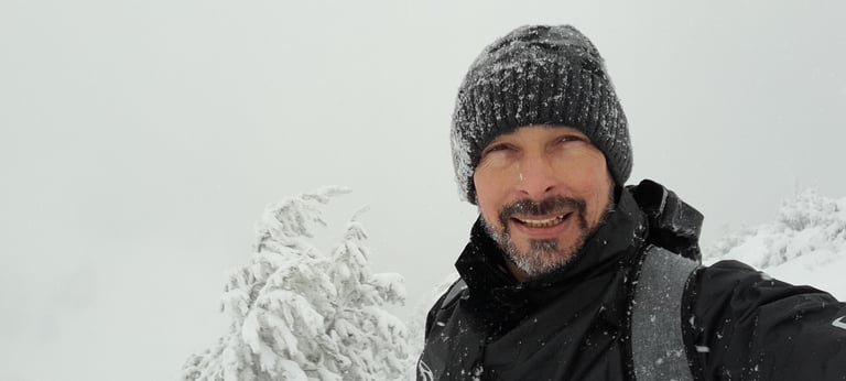 a man in a black jacket and a hat on a snowy day