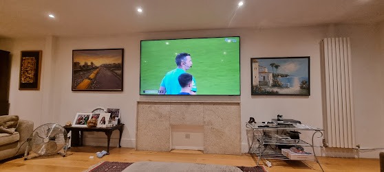 85-inch TV wall mounting above a fireplace with professional cable concealment.