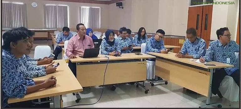 a group of people sitting at desks in a room