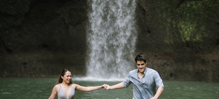 Prewedding couple standing in river at Tibumana Waterfall Bangli Bali