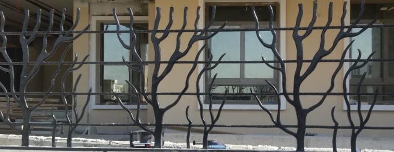 Decorative laser-cut aluminum boundary railing with modern geometric web design.