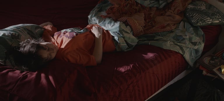 a woman laying on a bed with a blanket