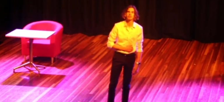 a woman standing on a stage with a chair and a chair